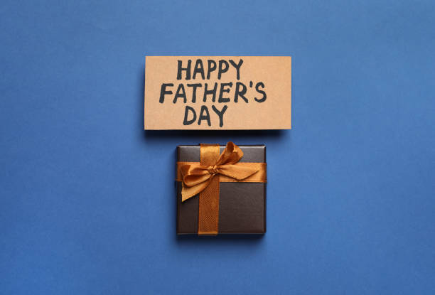 istock Card with phrase Happy Father's Day and gift box on blue background, flat lay 1407314109