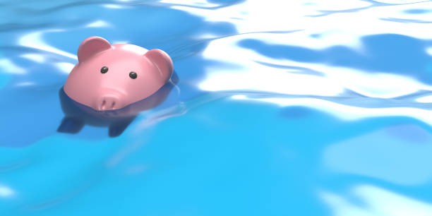 Drowning piggy bank in water, symbolizing debt crises stock photo