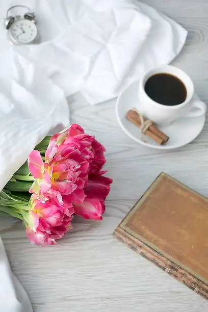 Spring flowers banner. Women's mothers day greeting card with pink tulips bouquet and espresso coffee in mug,cup, breakfast on white wooden background.