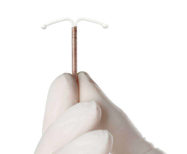 ginecólogo sosteniendo dispositivo anticonceptivo intrauterino de cobre sobre fondo blanco, primer plano - iucds fotografías e imágenes de stock