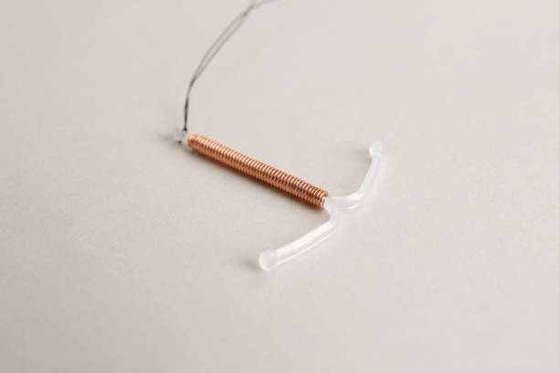 dispositif contraceptif intra-utérin en cuivre sur fond clair - iud photos et images de collection