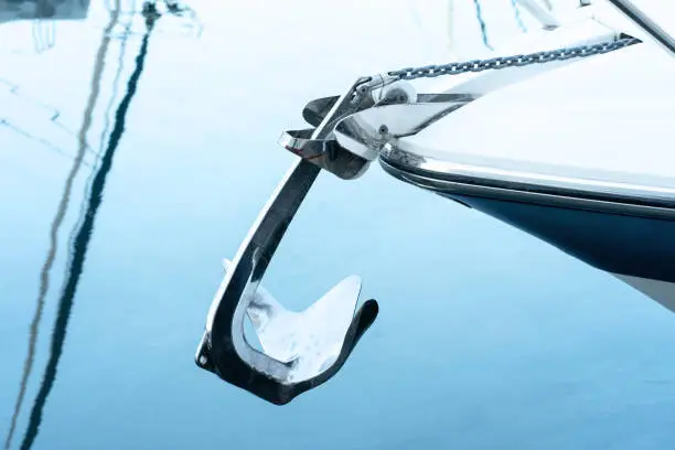 Photo of Bow anchor in polished stainless steel protruding from the bow of the boat.