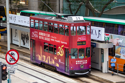Hong Kong - July 7, 2022 : A tram featuring an advertisement celebrating the 25th anniversary of Hong Kong's handover from Britain to China, in Central, Hong Kong.