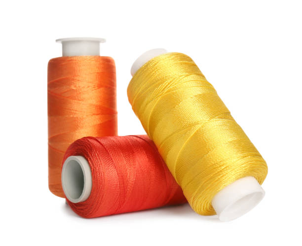 diversi fili da cucire colorati su sfondo bianco - sewing thread sewing item spool foto e immagini stock