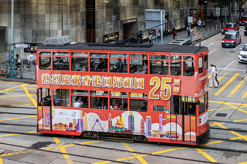 Hong Kong - July 7, 2022 : A tram featuring an advertisement celebrating the 25th anniversary of Hong Kong's handover from Britain to China, in Central, Hong Kong.