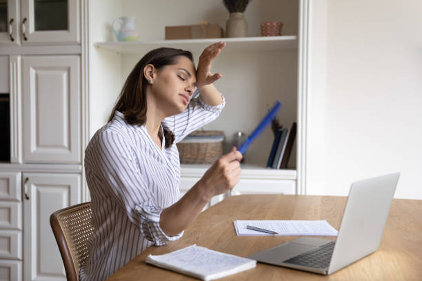istock Stressed unhappy young businesswoman using paper fan. 1407322127