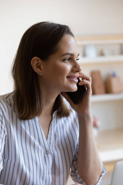 istock Smiling millennial attractive woman holding smartphone call talk. 1407322128