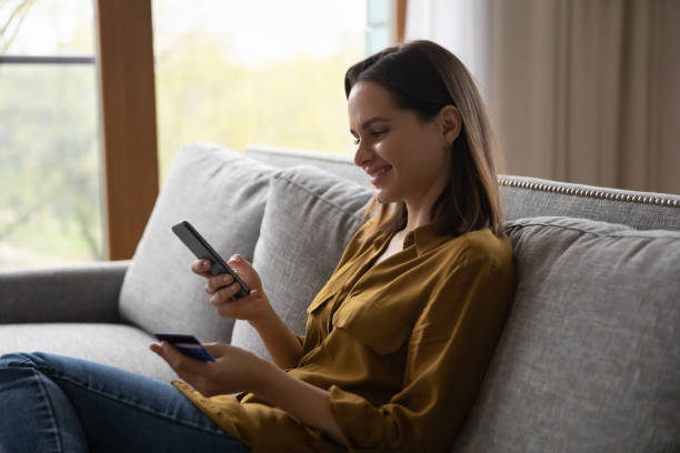 istock Smiling beautiful young woman shopping in mobile application. 1407322679