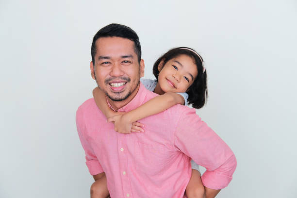 A father carry his daughter in his back with happy expression A father carry his daughter in his back with happy expression keluarga stock pictures, royalty-free photos & images