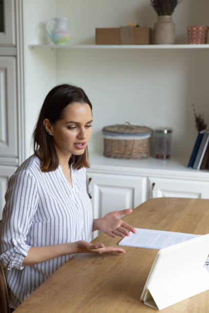 istock Focused millennial woman holding video call conversation using digital tablet. 1407323264