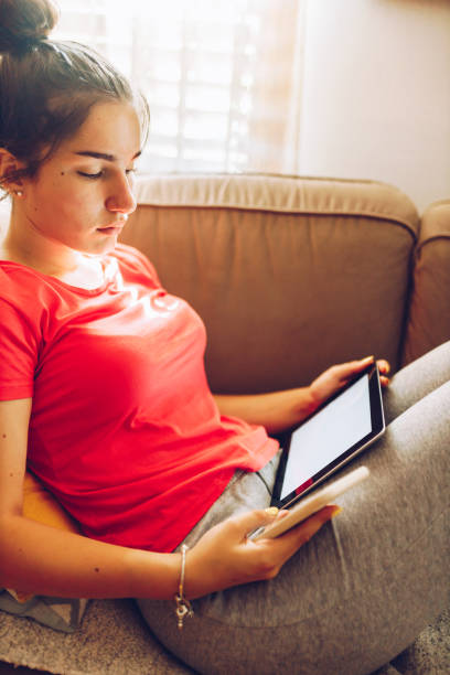 istock Young female  paying for a purchase using her smart phone and tablet 1407323333