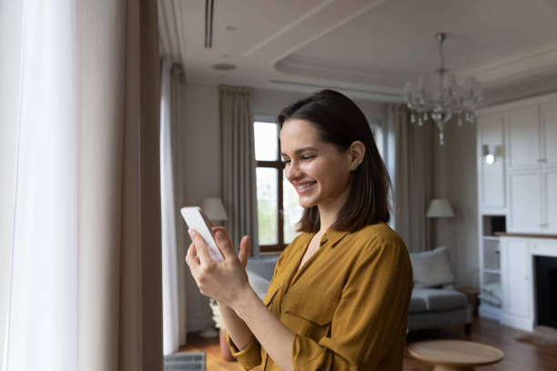 istock Happy beautiful young woman using cellphone at home. 1407323416