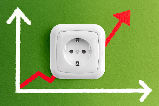 Two white electric sockets and a power plug isolated on green wall background, copy space. 3d illustration