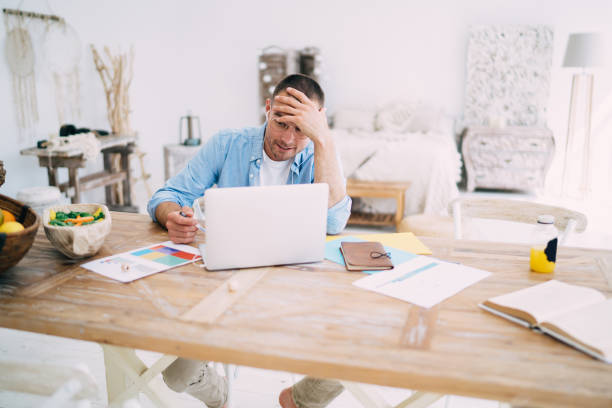 istock Concentrated male freelancer working on laptop from home 1407330559