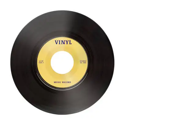 Photo of Closeup view of real gramophone vinyl record or phonograph music record with yellow label. Black musical single play disc 7 inch 45 rpm spiral groove. Stereo sound record. Isolated on white background