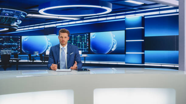 istock Beginning Evening News TV Program: Anchor Presenter Reporting on Business, Economy, Science, Politics. Television Cable Channel Anchorman Talks. Broadcast Network Newsroom Studio. 1407333739