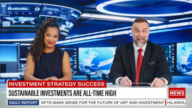 istock TV Live News Program: Two Professional Presenters Reporting On the Events. Television Cable Channel Newsroom Studio: Male and Female Anchors Talk. Mock-up Broadcasting Network Concept. Wide Shot 1407333962