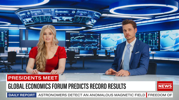 istock TV Live News Program: Two Presenters Reporting, Discuss Daily Events, Business, Economy, Science, Entertainment. Television Cable Channel Diverse Anchors Talk. Newsroom Studio Concept 1407334049