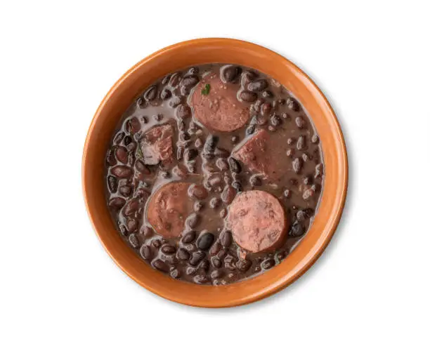 Traditional brazilian feijoada in a bowl isolated over white background.