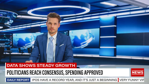 istock TV Live News Program: Charismatic White Male Presenter Reporting. Television Cable Channel Anchorman or Host Talking about Important Events. Network Broadcast Mock-up. Modern Newsroom Studio 1407334132
