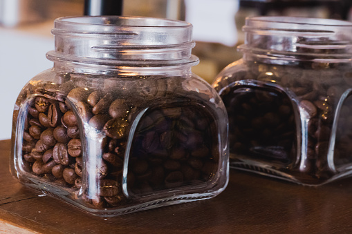 Roasted coffee beans in glass jar containers