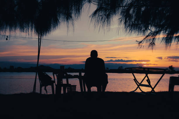 istock Silhouette of a man enjoying the sunset view 1407338336