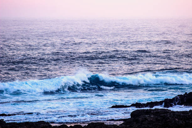 turquoise waves at dusk - color image light pink dramatic sky imagens e fotografias de stock