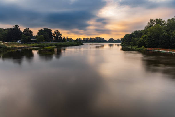 istock Beautiful cloudy sunrise at summer over long silent Odra river 1407343125