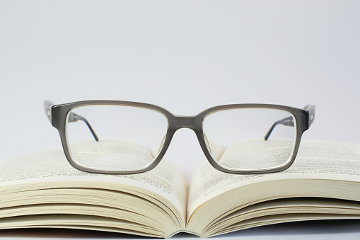 Photo of reading glasses placed on an open book