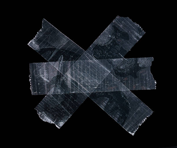 istock Transparent adhesive plastic tape pieces isolated on black background,Crumpled glue plastic sticky tape 1407343989