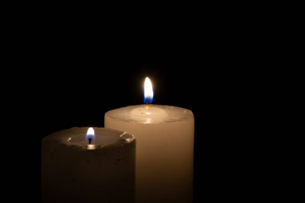 istock A thick candle with light burning in the darkness. 1407344681