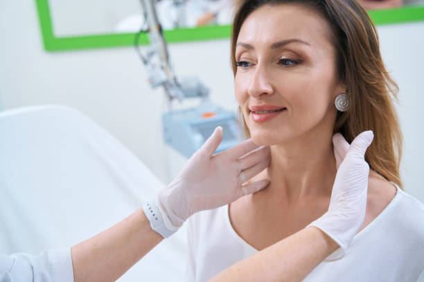 istock Dermatologist with gloved hands touches the patient neck 1407346365