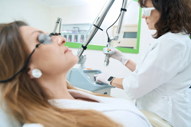 istock Cosmetologist adjusts laser device for removal of neoplasms 1407346481