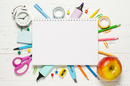 Children's accessories for study, creativity and office supplies on a white wooden background. Back to school concept. Copy space.