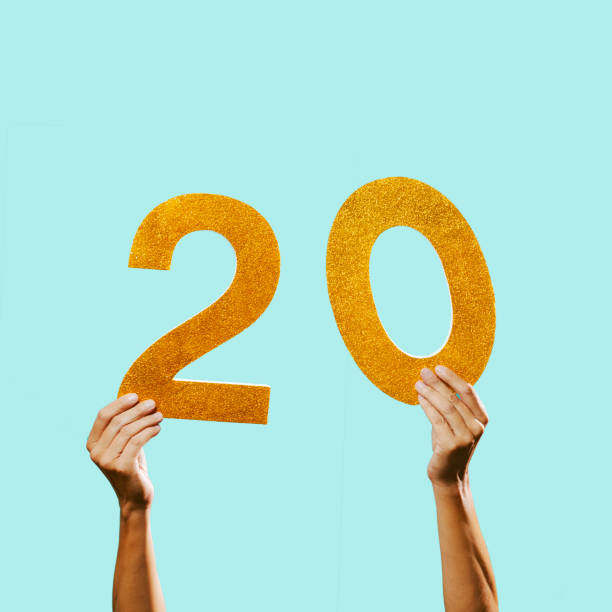 man grasps the number 20 in his hands