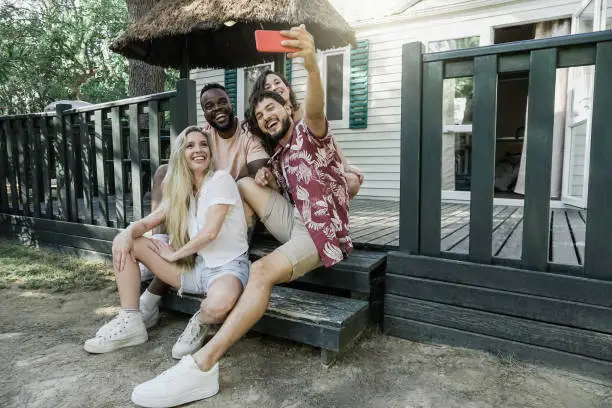 Multiracial happy friends taking selfie outdoor - Young people having fun in summer vacations - Focus on African man face