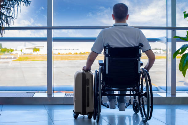 jovem em uma cadeira de rodas com bagagem no aeroporto - airport lounge airport one person bag - fotografias e filmes do acervo