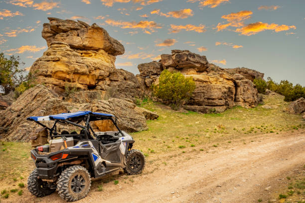 istock 4 wheeler ATV and side by side UTV lined up on sandstone with a beautiful butte and rainbow in the background. RZR Along the off road  Jeep and 4 wheeler trails near Moab, Utah. 1407352793