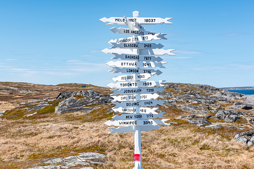 Signpost in volcanic landscape in direction of fissure near Litli-Hrútur Hill during 2023 eruption near mountain Fagradalsfjall, Iceland (text on sign Icelandic translates in English)