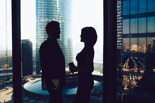 istock Unrecognizable modern business people standing in dark office and talking 1407354557