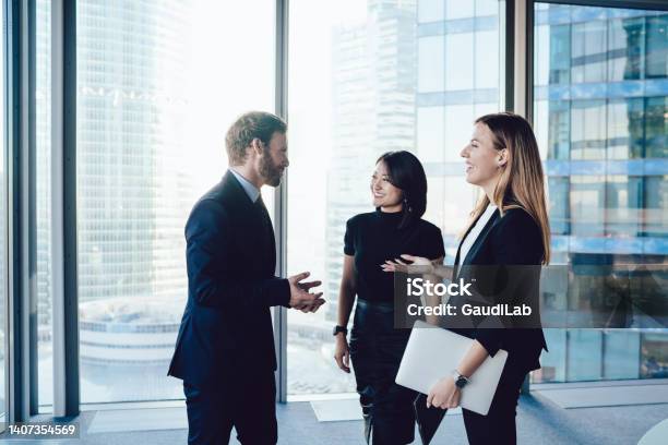 Young Well Dressed Coworkers In Office Talking And Laughing Joyfully Stock Photo - Download Image Now