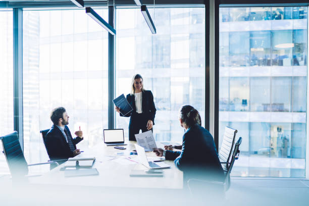 istock Smiling female executive manager talking to colleagues in boardroom 1407354585