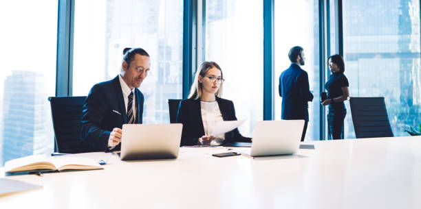istock Skilled Caucasian traders sitting at office desktop and checking mail search message with financial files for downloading via company internet during working time, brainstorming cooperation 1407354592