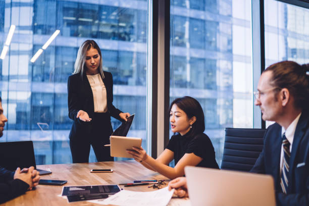 istock Serious businesswoman discussing project with diverse colleagues 1407354596