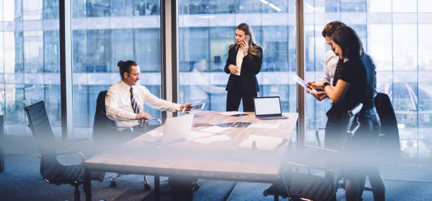 istock Confident business people using gadgets during meeting 1407354638