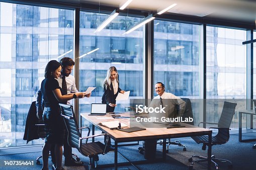 istock Group of diverse executive managers doing paperwork at meeting 1407354641