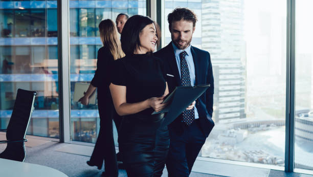 istock Smiling diverse colleagues reading documents together in office hallway 1407354695