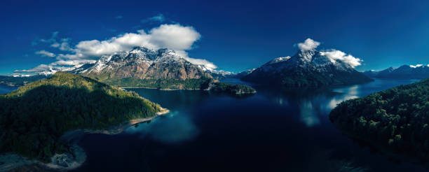 Beautiful aerial panoramic Argentinian patagonia landscape with snow capped mountains, lakes, clouds and reclections.