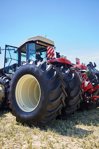 Several modern tractors stand side by side in the field. Equipment for agricultural or construction work.