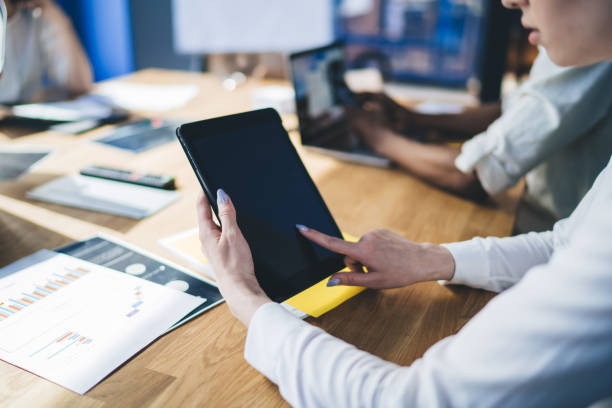 istock Female worker touching screen of laptop in bright office 1407355830